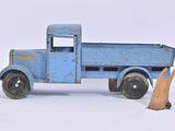 a blue toy truck with a man standing next to it