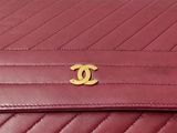 a close up of a red chanel bag with a gold logo on it