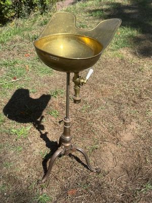 a birdbath that is sitting on a stand in the grass