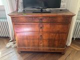 a wooden dresser with a television on top of it