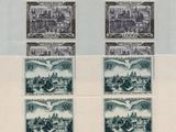 two stamps with a picture of a city on them on a sheet of paper