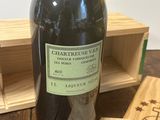 une bouteille de vin posée sur une table à côté d'une caisse en bois