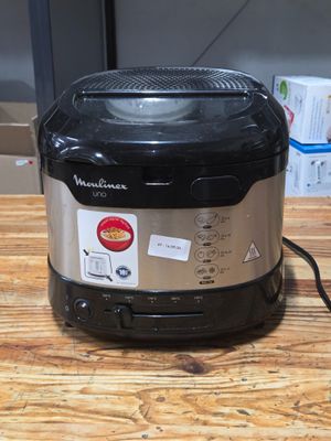 a black and silver air fryer sitting on a wooden table