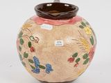 a vase with a flower design on it sitting on a table