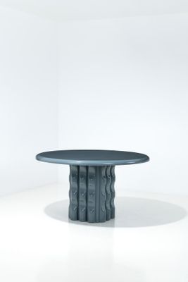 une image représentant une table au plateau noir posée sur une surface blanche