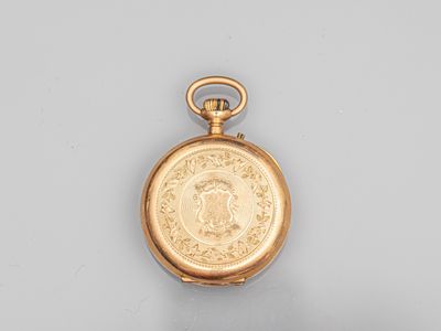 une vieille montre de poche en or avec une pièce de monnaie sur le cadran