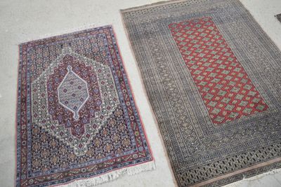 deux tapis orientaux posés côte à côte sur le sol d'une pièce