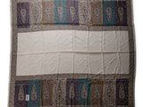 a white blanket with a blue and brown design on it