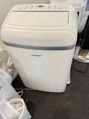 une photo d'une petite machine à laver blanche dans un coin d'une pièce