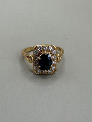 a close up of a gold ring with a black stone surrounded by white diamonds