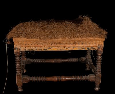 un petit banc en bois avec une assise en paille