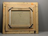 an old picture frame sitting on top of a shelf in a room