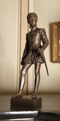 a bronze statue of a man with a sword on a table