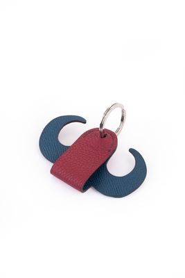 porte-clés en cuir bleu et rouge représentant une moustache sur fond blanc