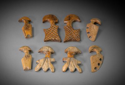 six pièces de bois sculpté sont disposées sur une surface grise