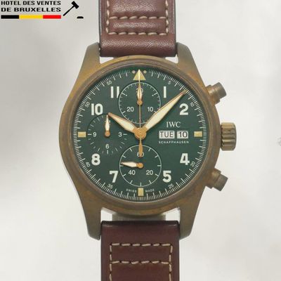 une image représentant une montre avec un cadran vert et un bracelet en cuir marron