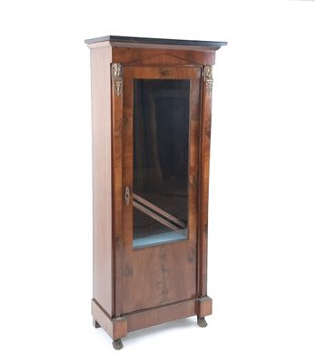 une petite armoire en bois munie d'une porte vitrée