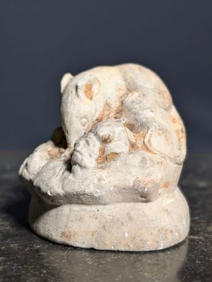 une petite statue représentant un chat assis sur une table