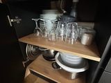 a shelf with dishes and glasses on it in the kitchen