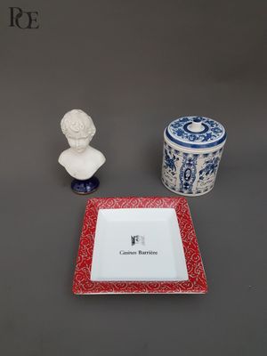 a red plate with a white plate and a blue and white plate with a bust of a man on it