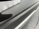 a close up of a person ' s hand on the bumper of a car