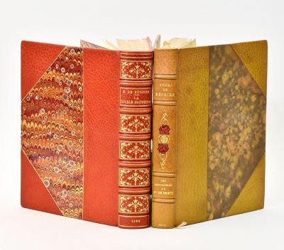 two books are stacked on top of each other on a white surface