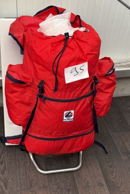 a red backpack sitting on top of a folding chair