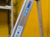 a ladder that is leaning against a yellow wall