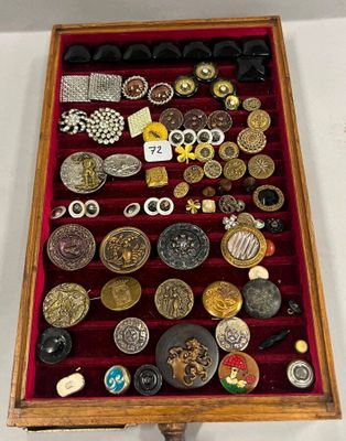 une vitrine en bois remplie d'une multitude de boutons de toutes sortes