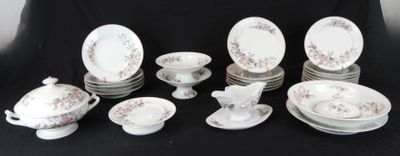 de nombreuses assiettes, tasses et soucoupes posées sur une table noire
