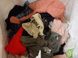 a pile of clothes in a bin on the floor