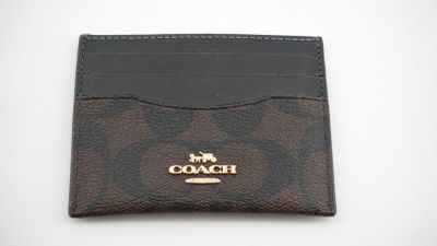 un porte-cartes de type « coach » à motifs marron et noir