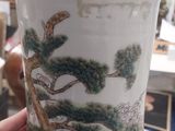 a vase with a painting on it sitting on a table