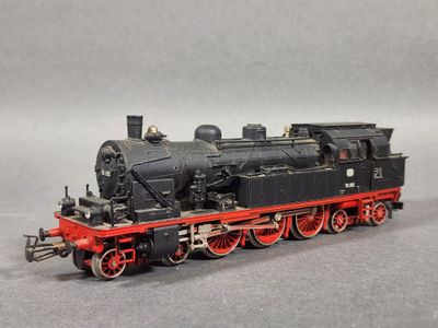 une locomotive noire et rouge sur un fond gris