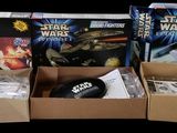three boxes of star wars toys sit on a black surface