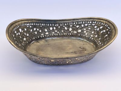 an antique silver plate with a decorative design on it