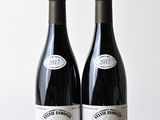 two bottles of wine sitting on a table next to each other