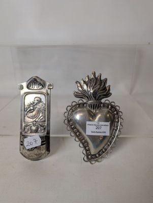 pair of silver plated heart shaped objects on display in a glass case