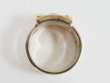 a silver ring with a gold band on a white surface