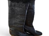 pair of black leather boots with fur on the soles