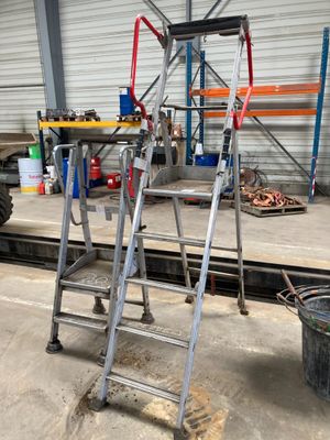 a ladder that is sitting on the ground in front of a building