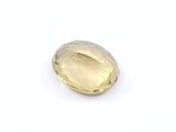 a yellow sapphire stone on a white surface
