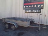 a trailer with a trailer attached to it in front of a building