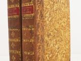 an old pair of books sitting on top of a white surface