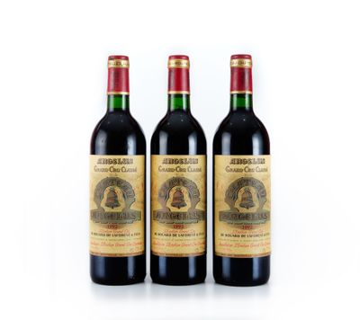 trois bouteilles de vin posées les unes à côté des autres sur une surface blanche