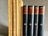 trois livres sont posés sur une table à côté d'une pile de livres
