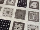an image of a patchwork rug with a cat laying on it