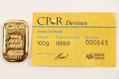 credit card with a gold bar next to it on a white surface