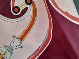 a red and white scarf with a picture of an elephant on it