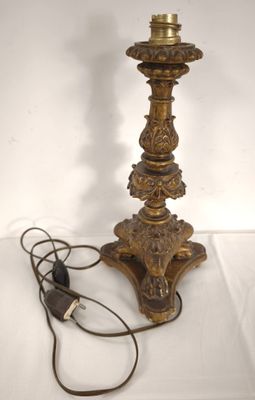 an antique brass table lamp with a cord plugged to it